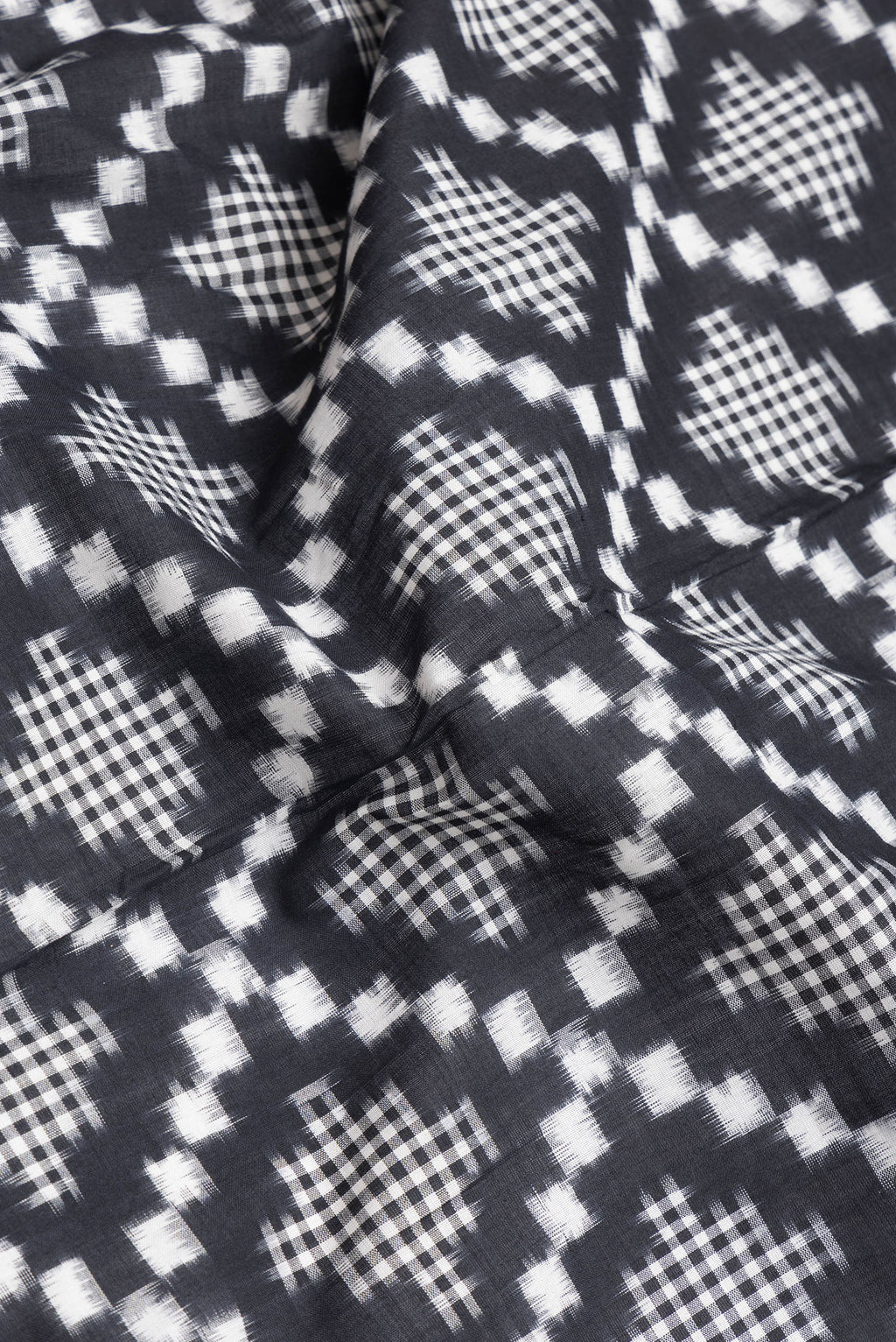 Close up of Black Dual Tone Double Ikat Saree with Ikat Print on the body and Plain Border.  displaying folds