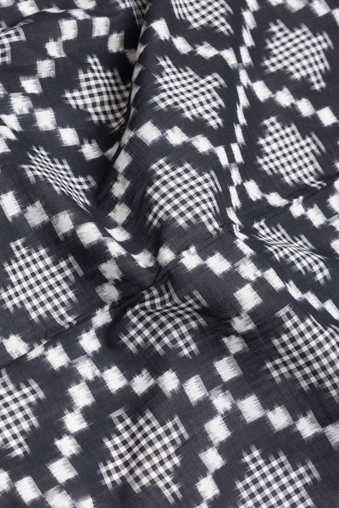 Close up of Black Dual Tone Double Ikat Saree with Ikat Print on the body and Plain Border.  displaying folds