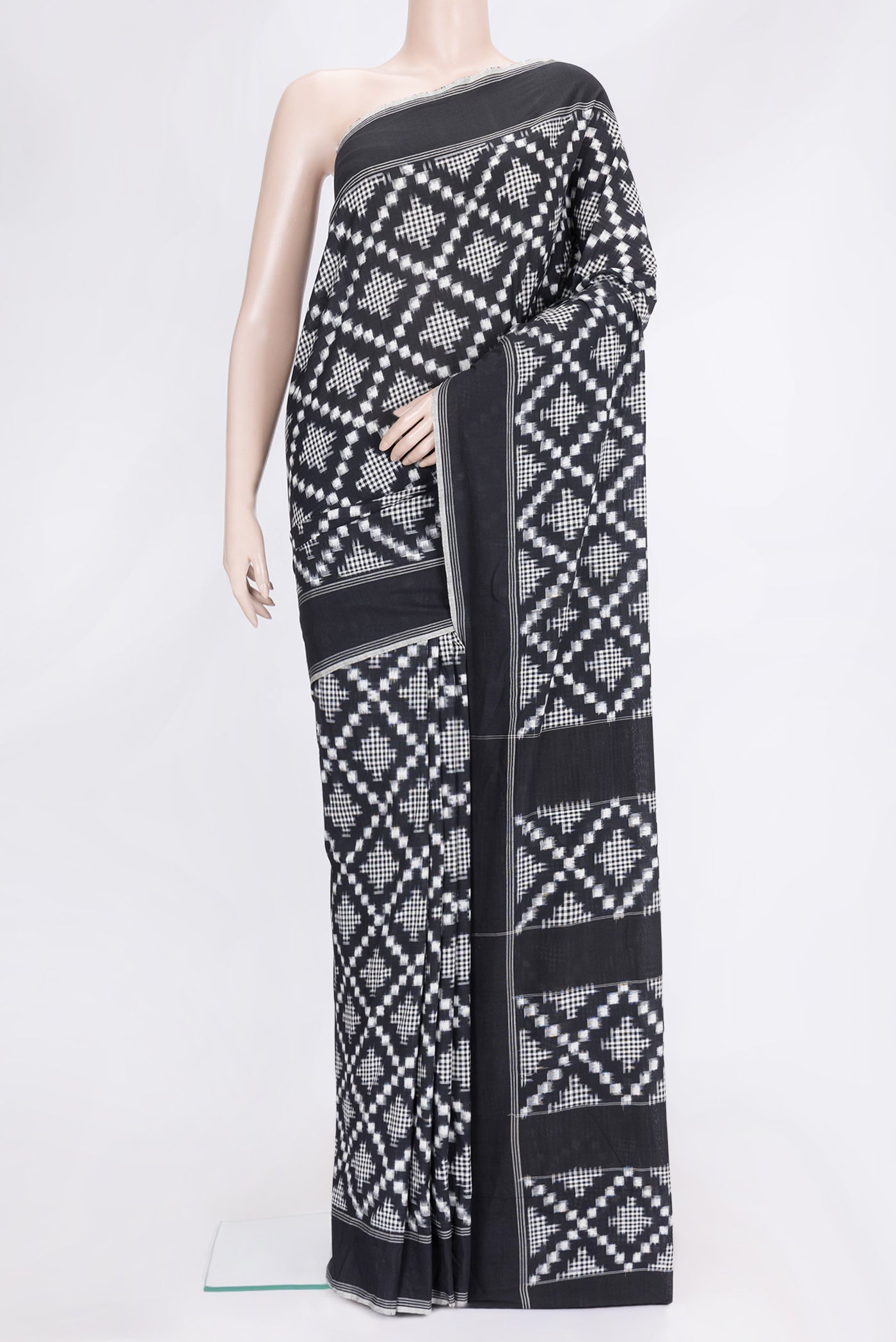Black Dual Tone Double Ikat Saree with Ikat Print on the body and Plain Border.  displayed on a mannequin