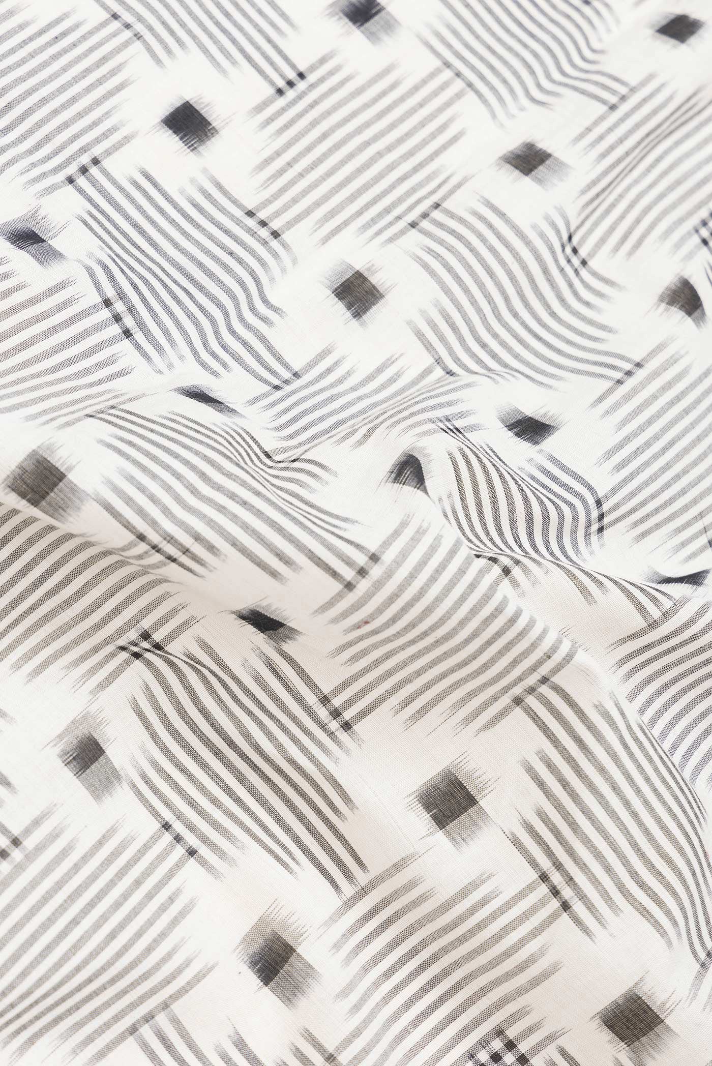 Close up of Off White Dual Tone Double Ikat Saree with Ikat Print on the body and Thread Border.  displaying folds