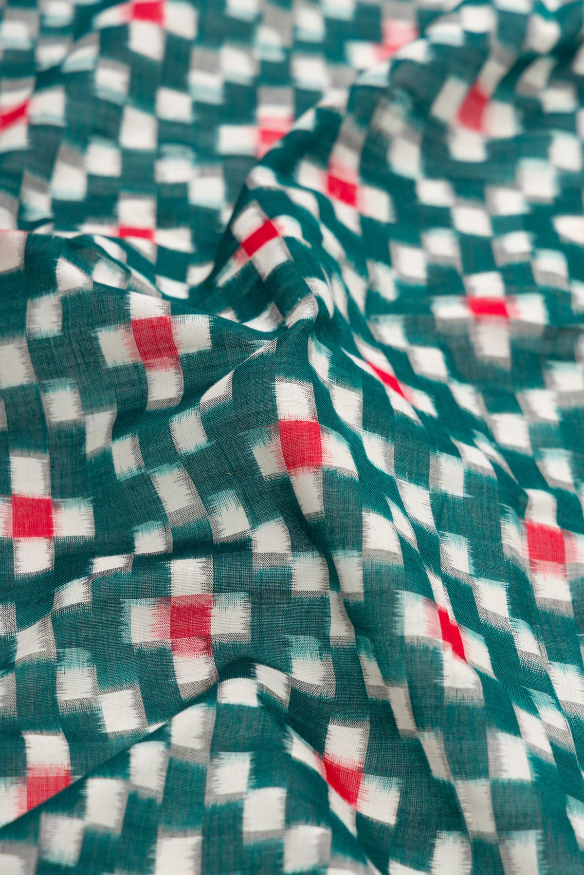 Close up of Bottle Green Dual Tone Double Ikat Saree with Ikat Print on the body and Plain Border.  displaying folds