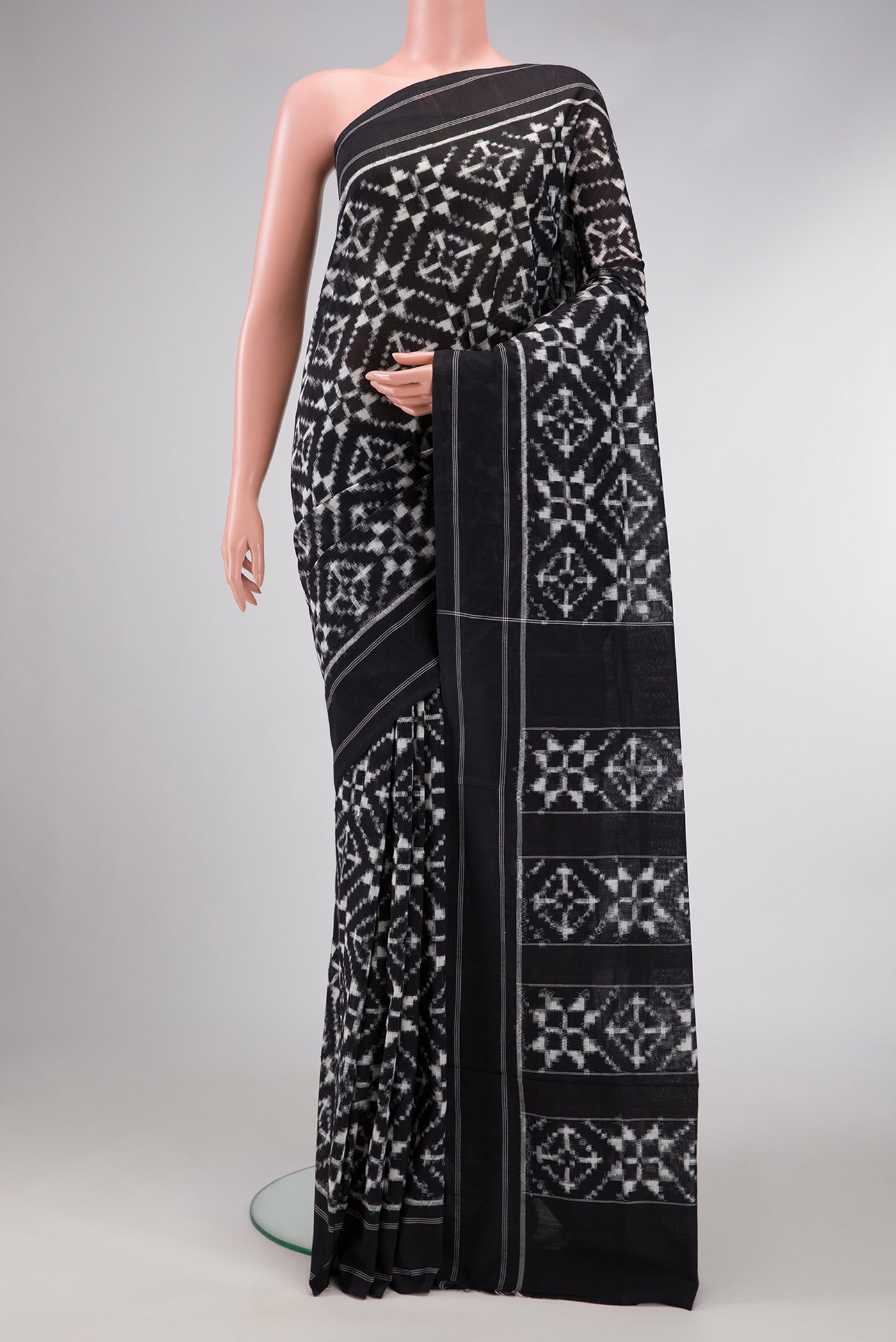 Black Dual Tone Double Ikat Saree with Ikat Print on the body and Plain Border.  displayed on a mannequin
