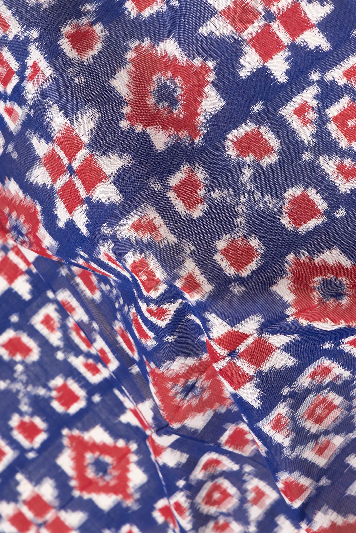 Close up of Navy Blue Dual Tone Double Ikat Saree with Ikat Print on the body and Thread Border.  displaying folds