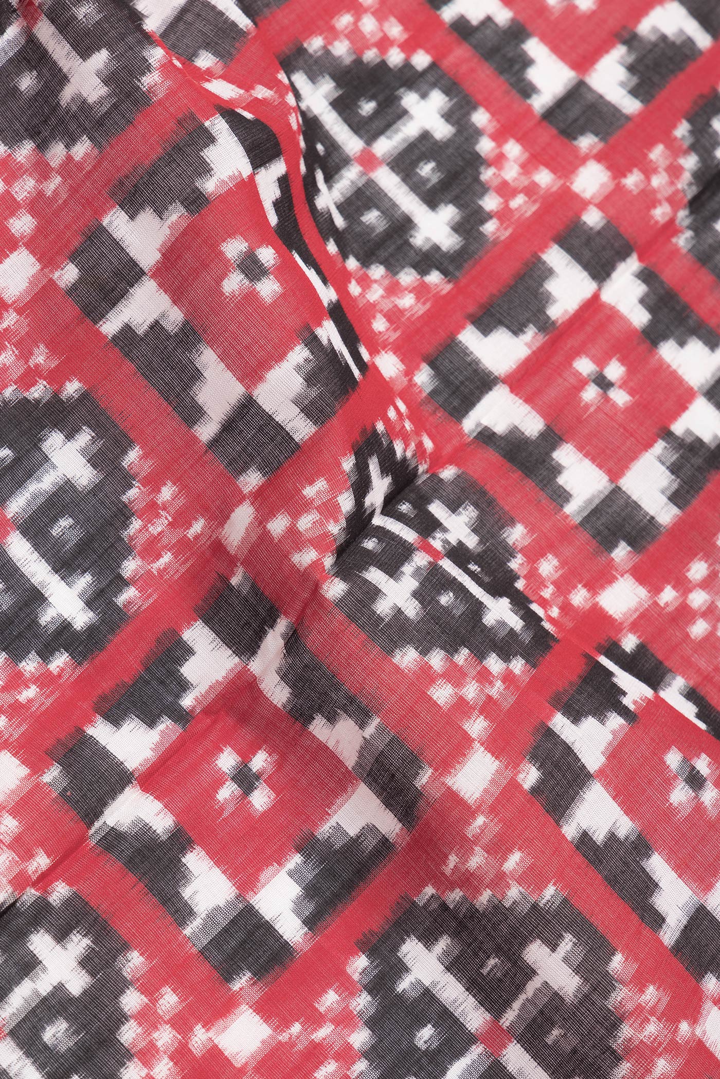 Close up of Black and Red Color Double Ikat Saree with Ikat Print on the body and Plain Border.  displaying folds