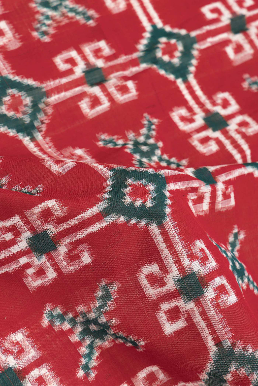 Close up of Red Dual Tone Double Ikat Saree with Ikat Print on the body and Thread Border.  displaying folds