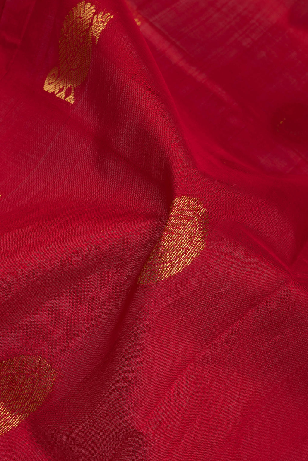 Close up of Red Silk Cotton Saree with Zari Butta on the body and Zari Border.  displaying folds