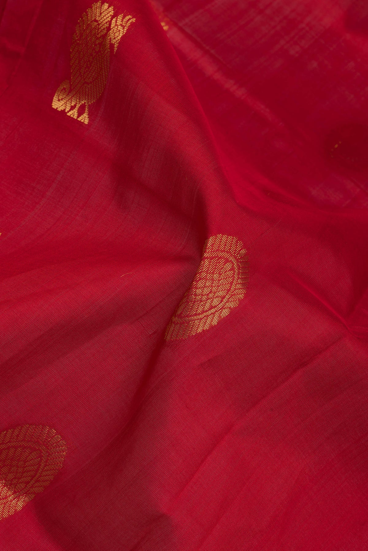 Close up of Red Silk Cotton Saree with Zari Butta on the body and Zari Border.  displaying folds