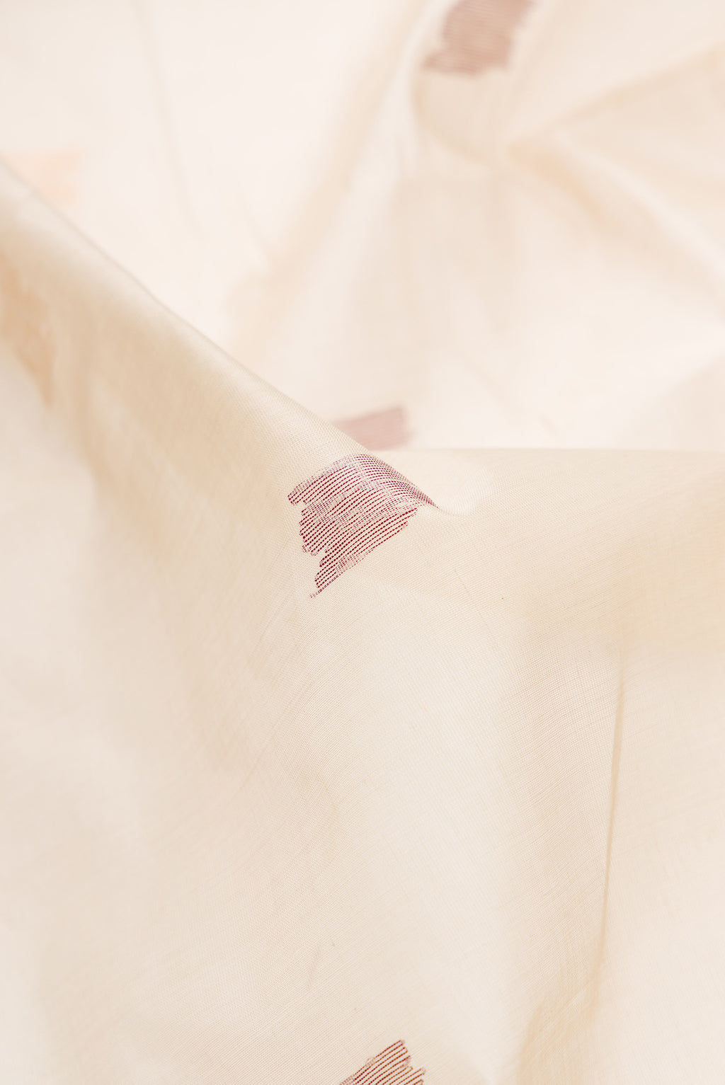 Close up of Beige Dual Tone Uppada Cotton Saree with Zari Butta on the body and Zari Border.  displaying folds
