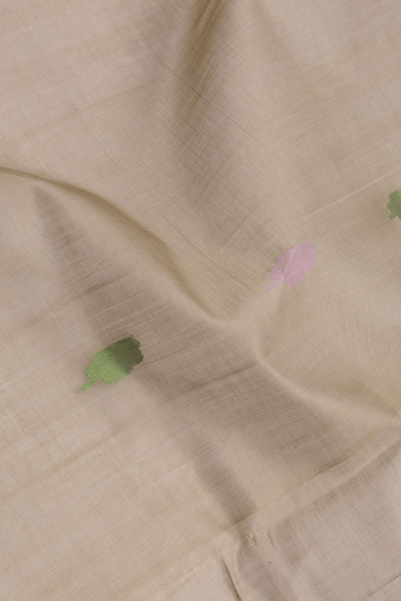 Close up of Dark Beige Uppada Cotton Saree with Zari And Thread Butta on the body and Zari Border.  displaying folds