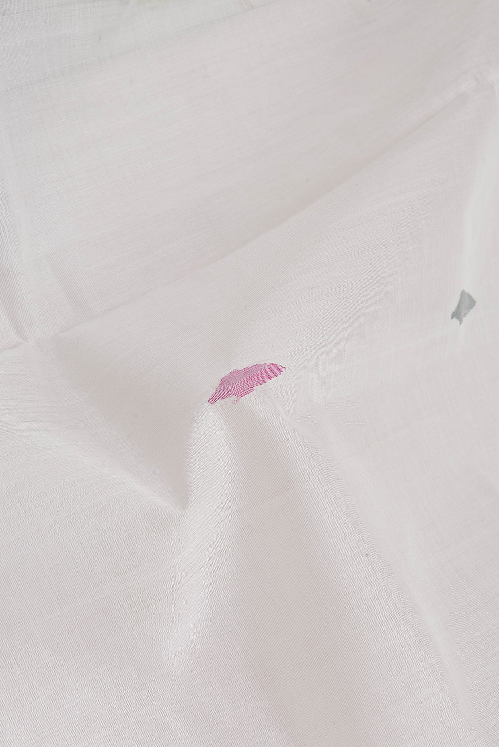 Close up of Off White Uppada Cotton Saree with Zari And Thread Butta on the body and Zari Border.  displaying folds