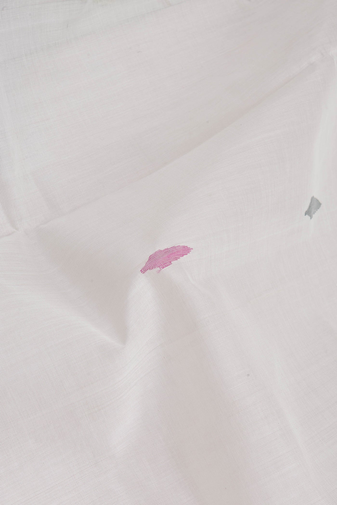 Close up of Off White Uppada Cotton Saree with Zari And Thread Butta on the body and Zari Border.  displaying folds