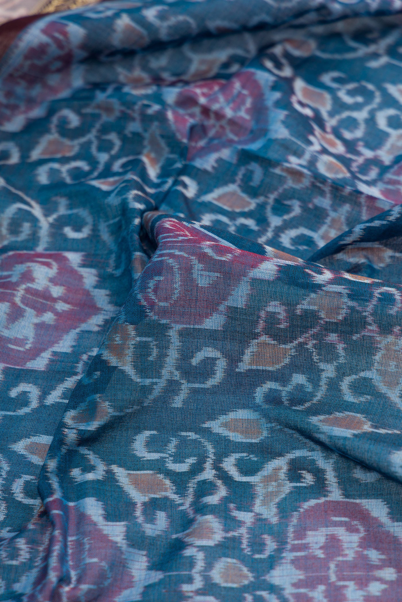 Close up of Blue Dual Tone Double Ikat Saree with Ikat Print on the body and Thread Border.  displaying folds