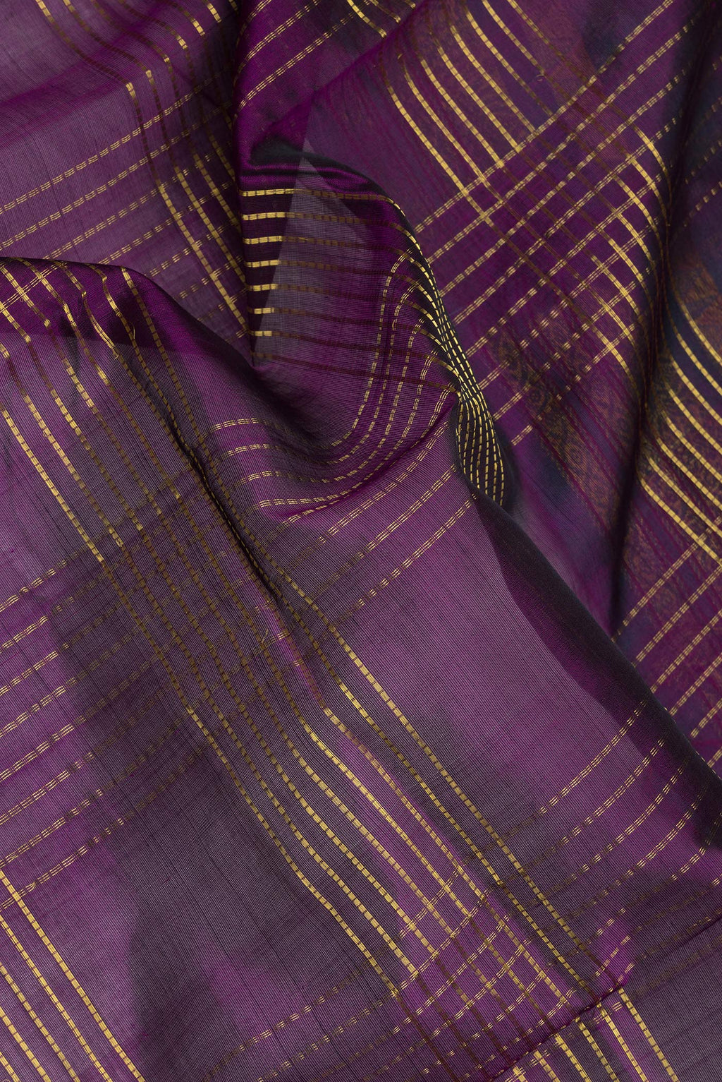 Close up of Purple Silk Cotton Saree with Checked design on the body and Zari And Thread Border.  displaying folds