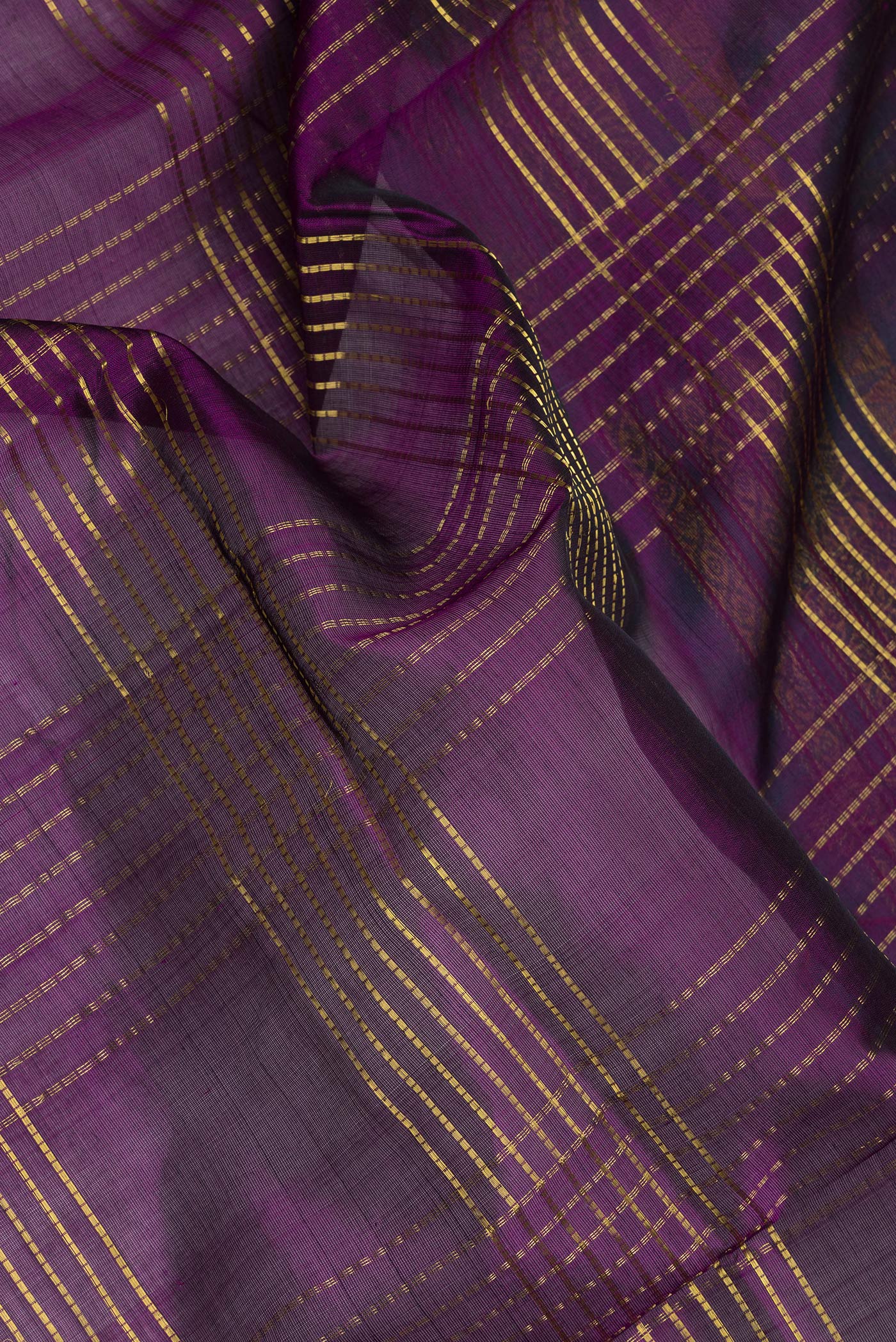 Close up of Purple Silk Cotton Saree with Checked design on the body and Zari And Thread Border.  displaying folds