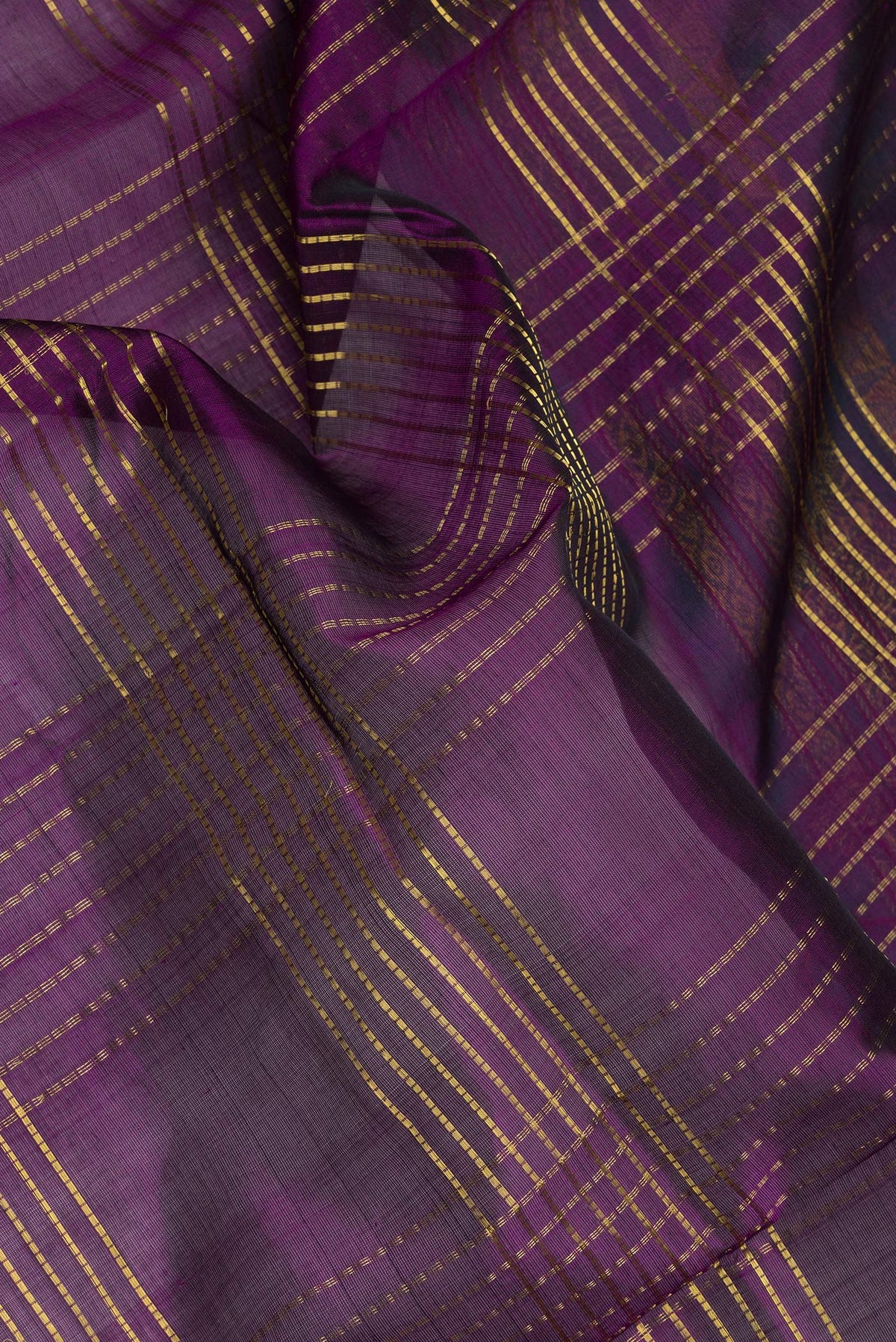 Close up of Purple Silk Cotton Saree with Checked design on the body and Zari And Thread Border.  displaying folds