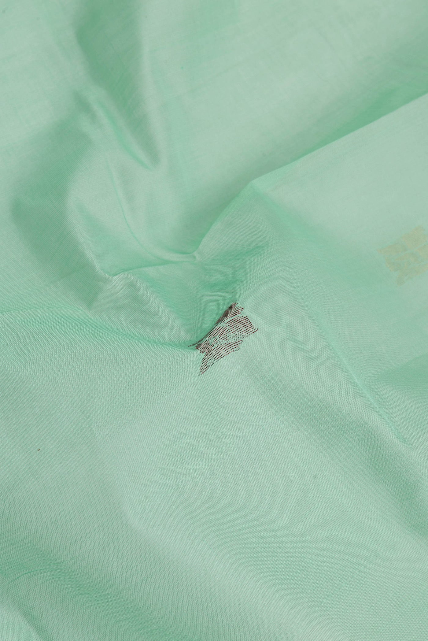 Close up of Sea Green Uppada Cotton Saree with Zari And Thread Butta on the body and Zari Border.  displaying folds