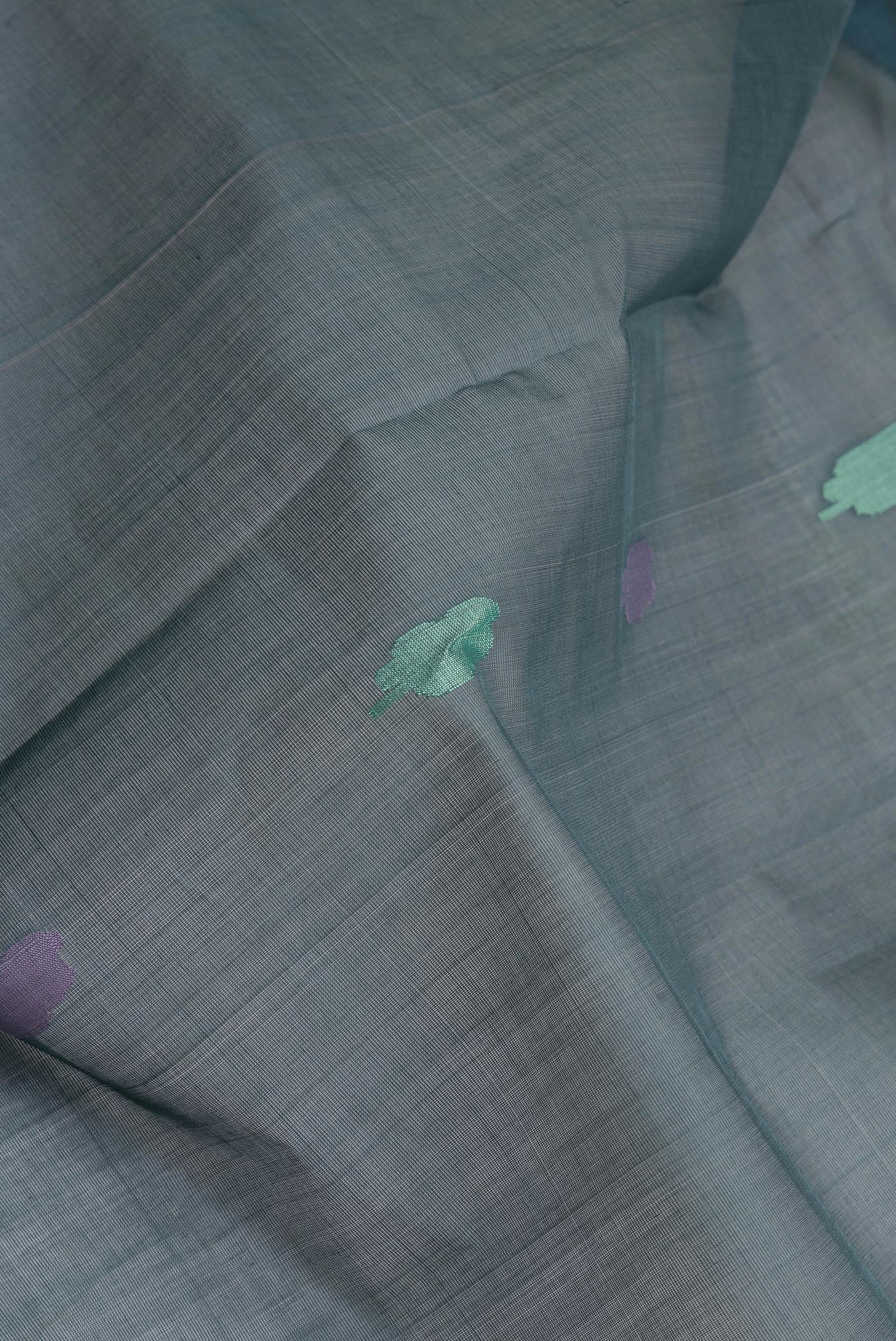 Close up of Green Uppada Cotton Saree with Zari And Thread Butta on the body and Zari Border.  displaying folds