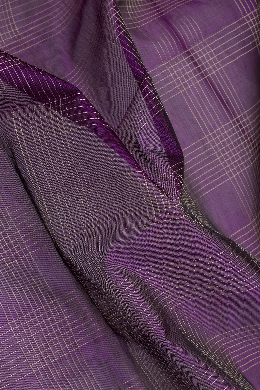 Close up of Purple Silk Cotton Saree with Checked design on the body and Zari And Thread Border.  displaying folds