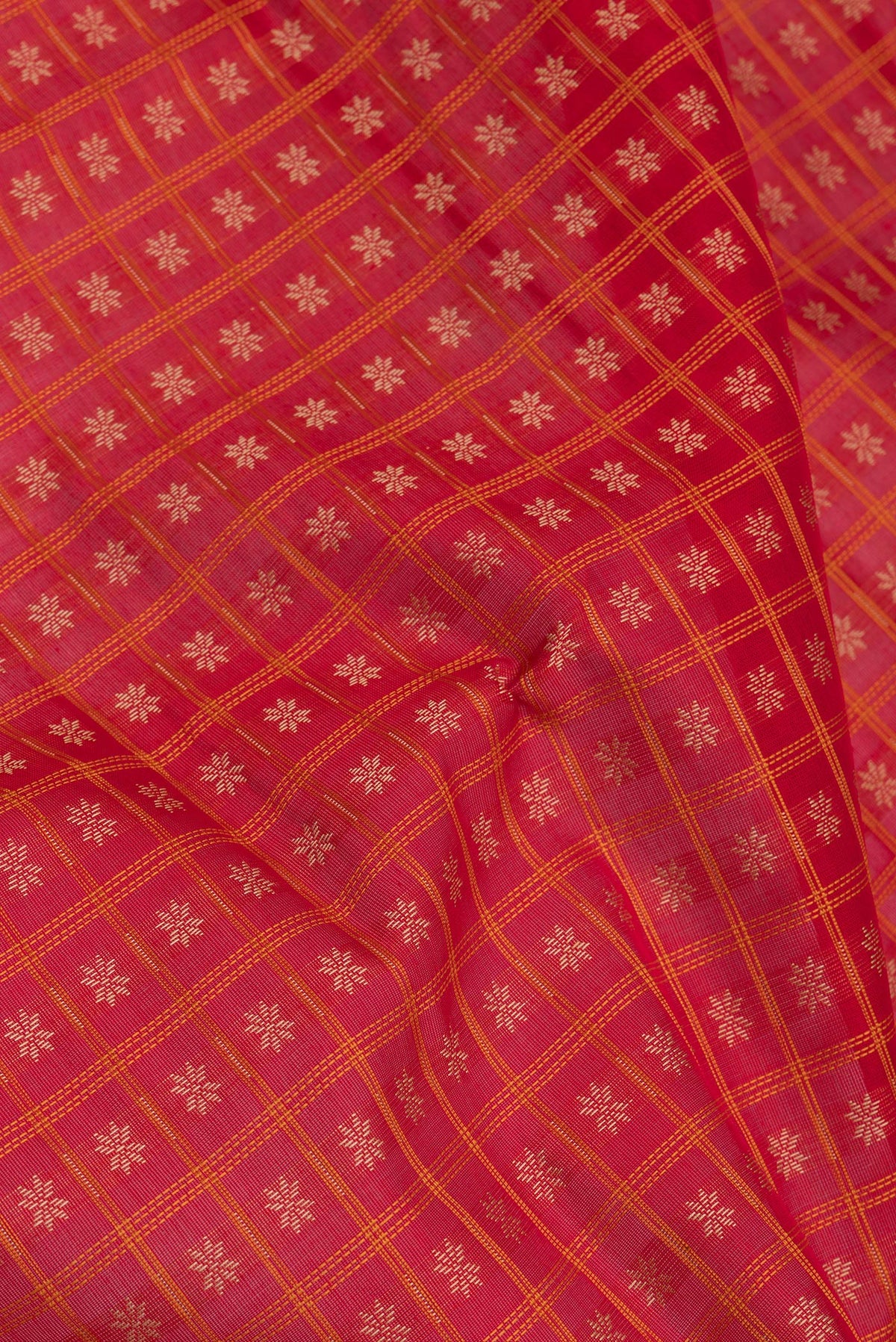 Close up of Red Silk Cotton Saree with Checked design on the body and Zari And Thread Border.  displaying folds