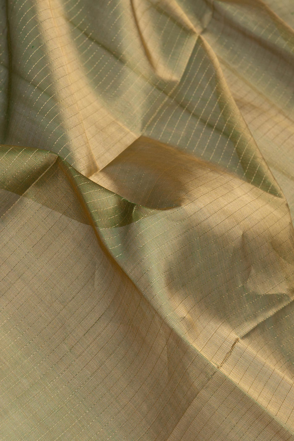 Close up of Green Dual Tone Silk Cotton Saree with Stripes on the body and Zari And Thread Border.  displaying folds