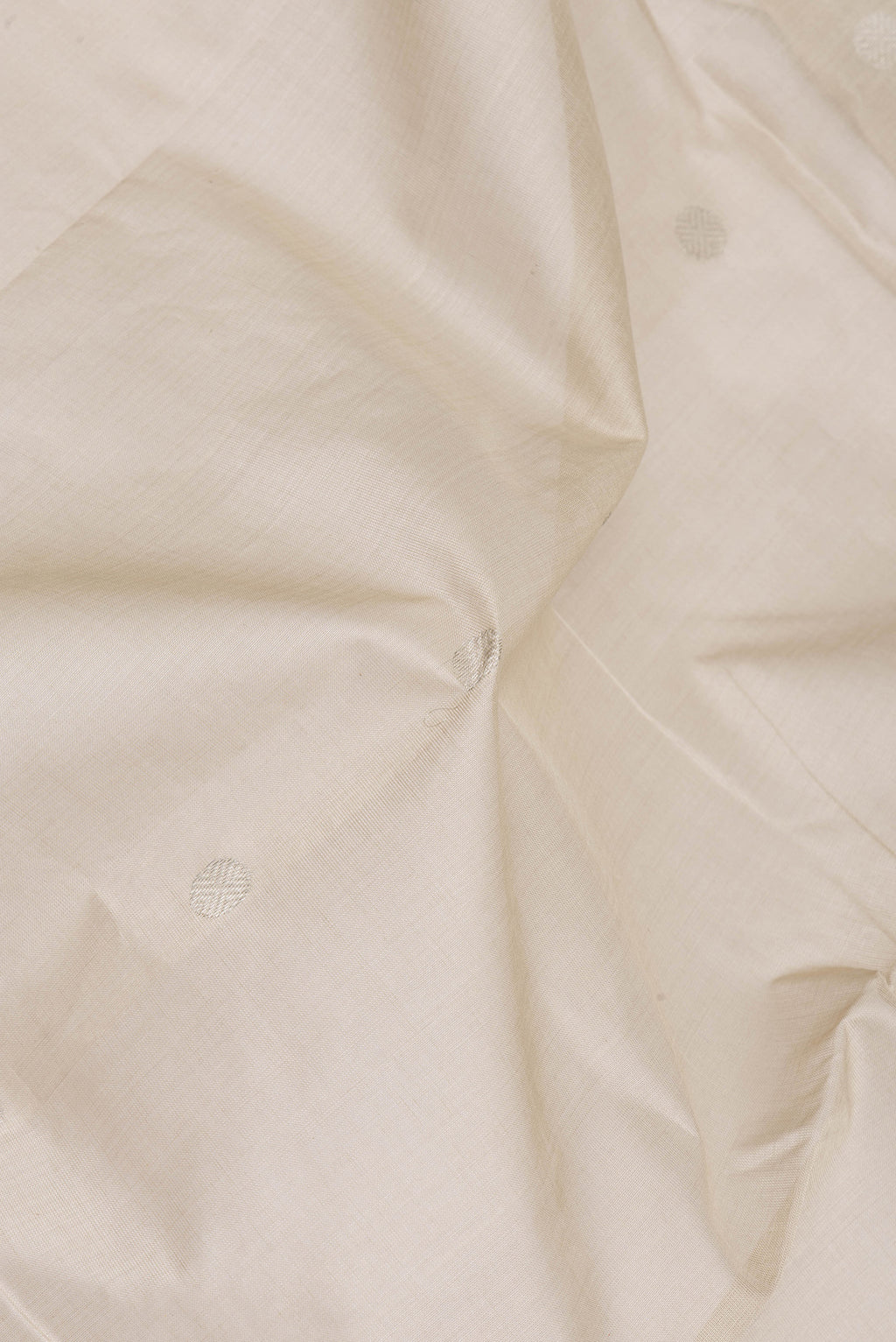 Close up of Beige Uppada Cotton Saree with Zari Butta on the body and Zari Border.  displaying folds