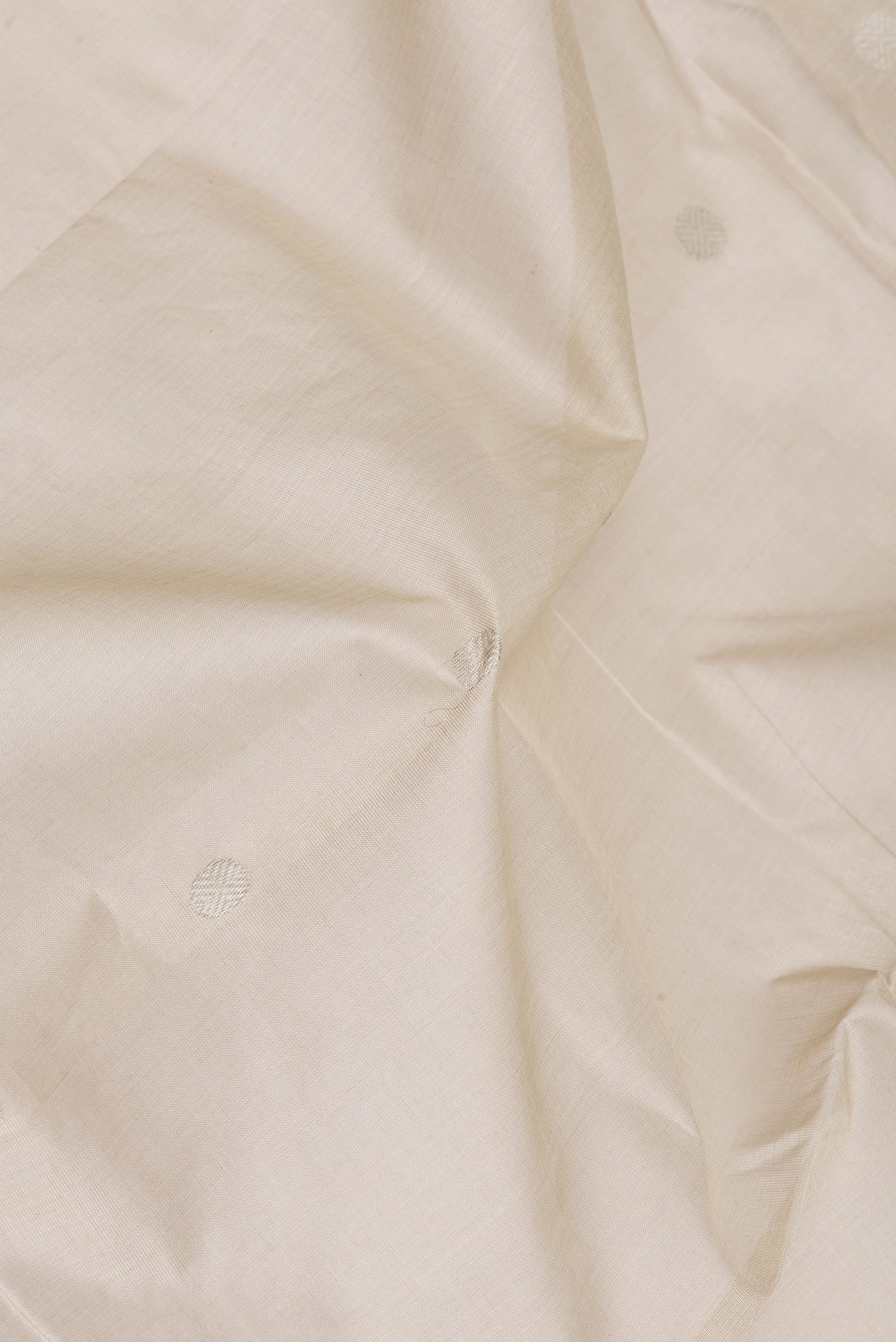 Close up of Beige Uppada Cotton Saree with Zari Butta on the body and Zari Border.  displaying folds
