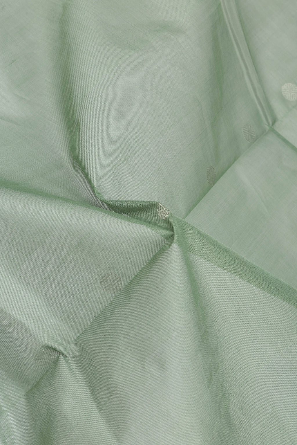 Close up of Pista Green Uppada Cotton Saree with Zari Butta on the body and Zari Border.  displaying folds
