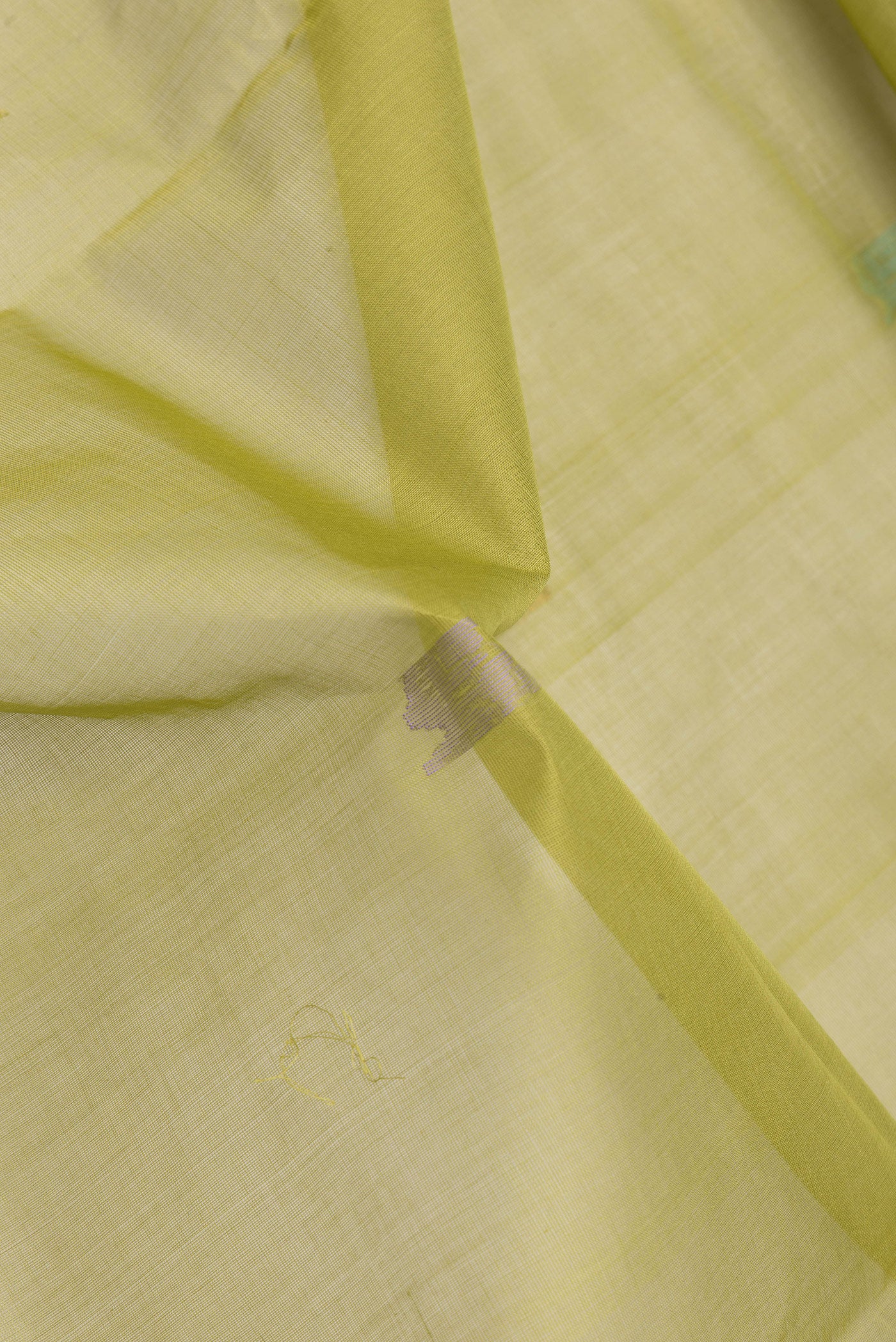 Close up of Pista Green Dual Tone Uppada Cotton Saree with Zari And Thread Butta on the body and Zari Border.  displaying folds
