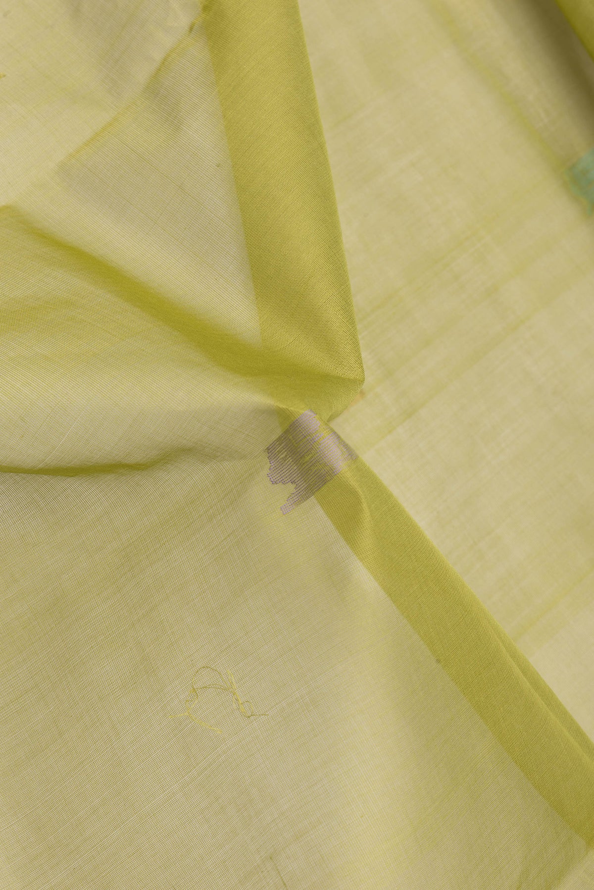 Close up of Pista Green Dual Tone Uppada Cotton Saree with Zari And Thread Butta on the body and Zari Border.  displaying folds