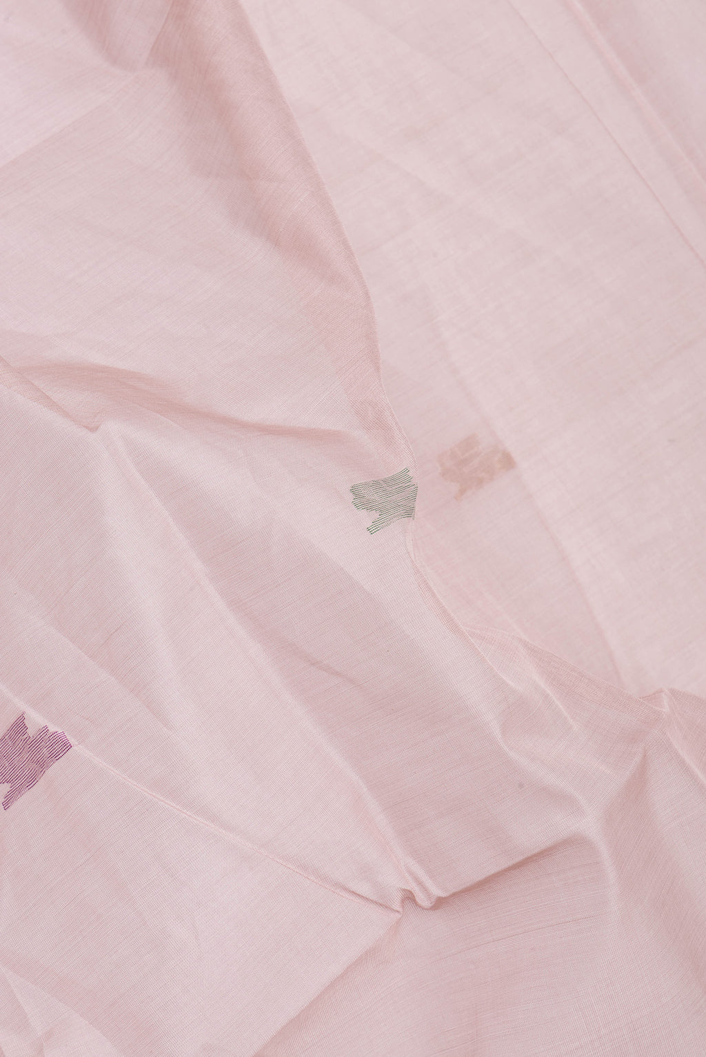Close up of Rose Gold Uppada Cotton Saree with Zari And Thread Butta on the body and Zari Border.  displaying folds