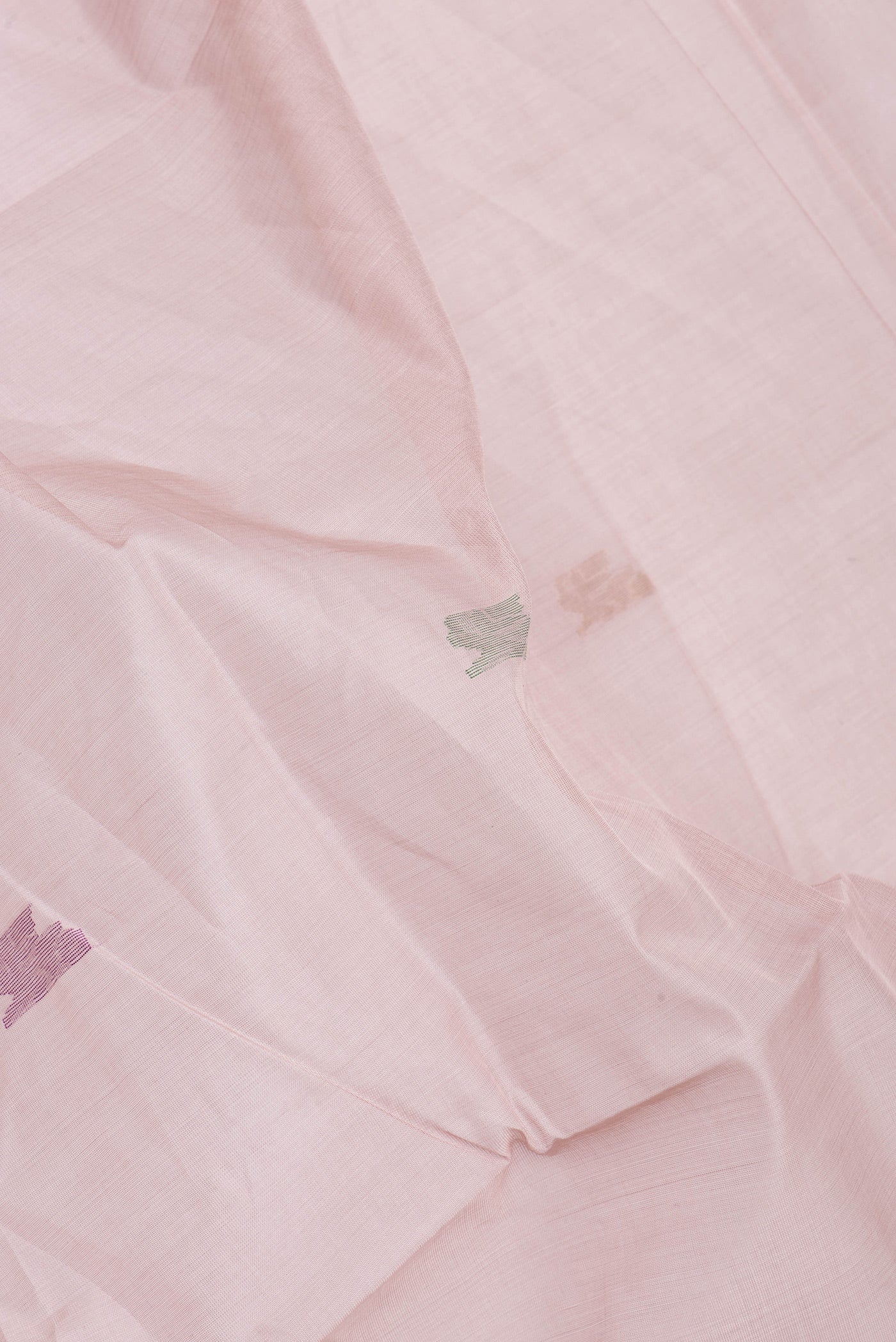 Close up of Rose Gold Uppada Cotton Saree with Zari And Thread Butta on the body and Zari Border.  displaying folds