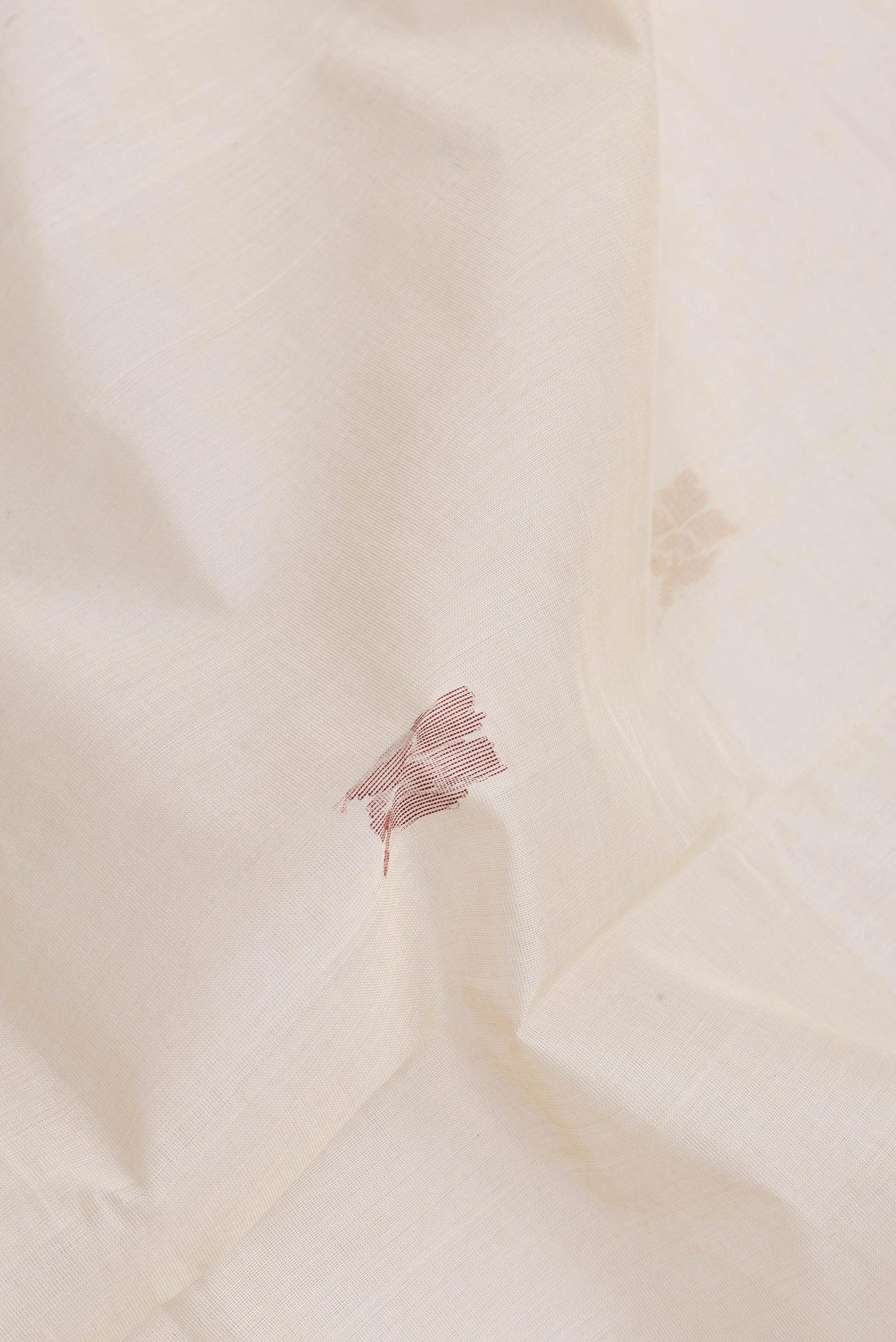 Close up of Beige Uppada Cotton Saree with Zari And Thread Butta on the body and Zari Border.  displaying folds