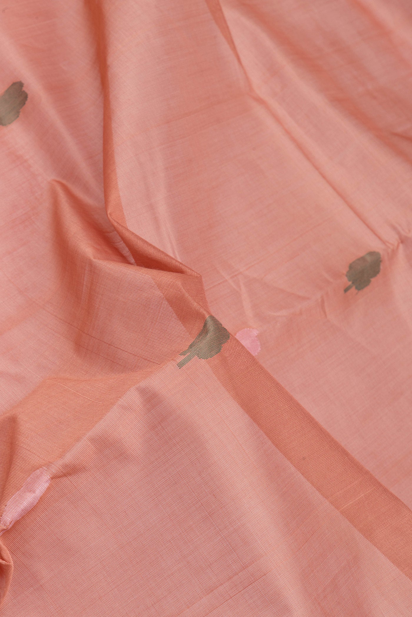 Close up of Rose Gold Uppada Cotton Saree with Thread Butta on the body and Zari Border.  displaying folds