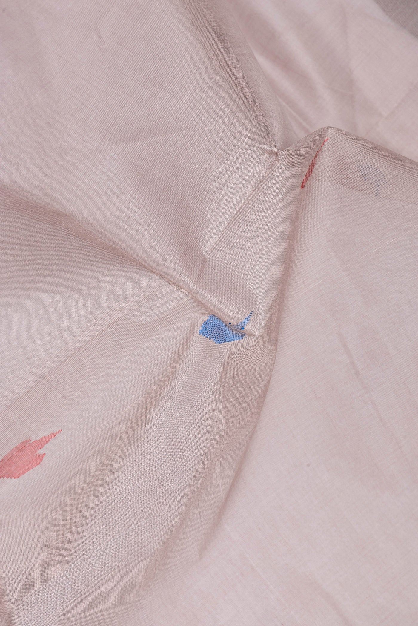 Close up of Beige Uppada Cotton Saree with Thread Butta on the body and Zari Border.  displaying folds