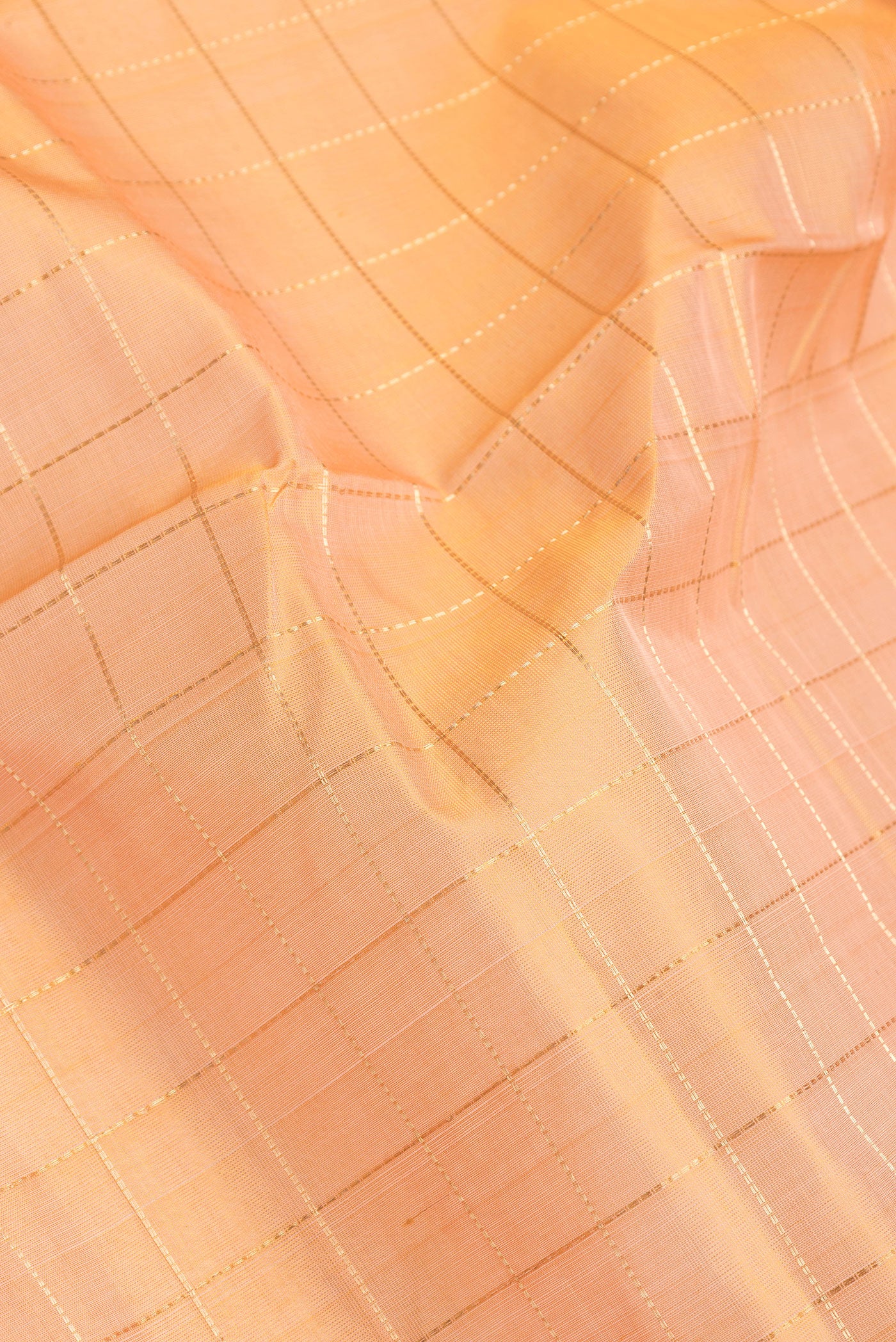 Close up of Golden Peach Dual Tone Silk Cotton Saree with Checked design on the body and Zari Border.  displaying folds