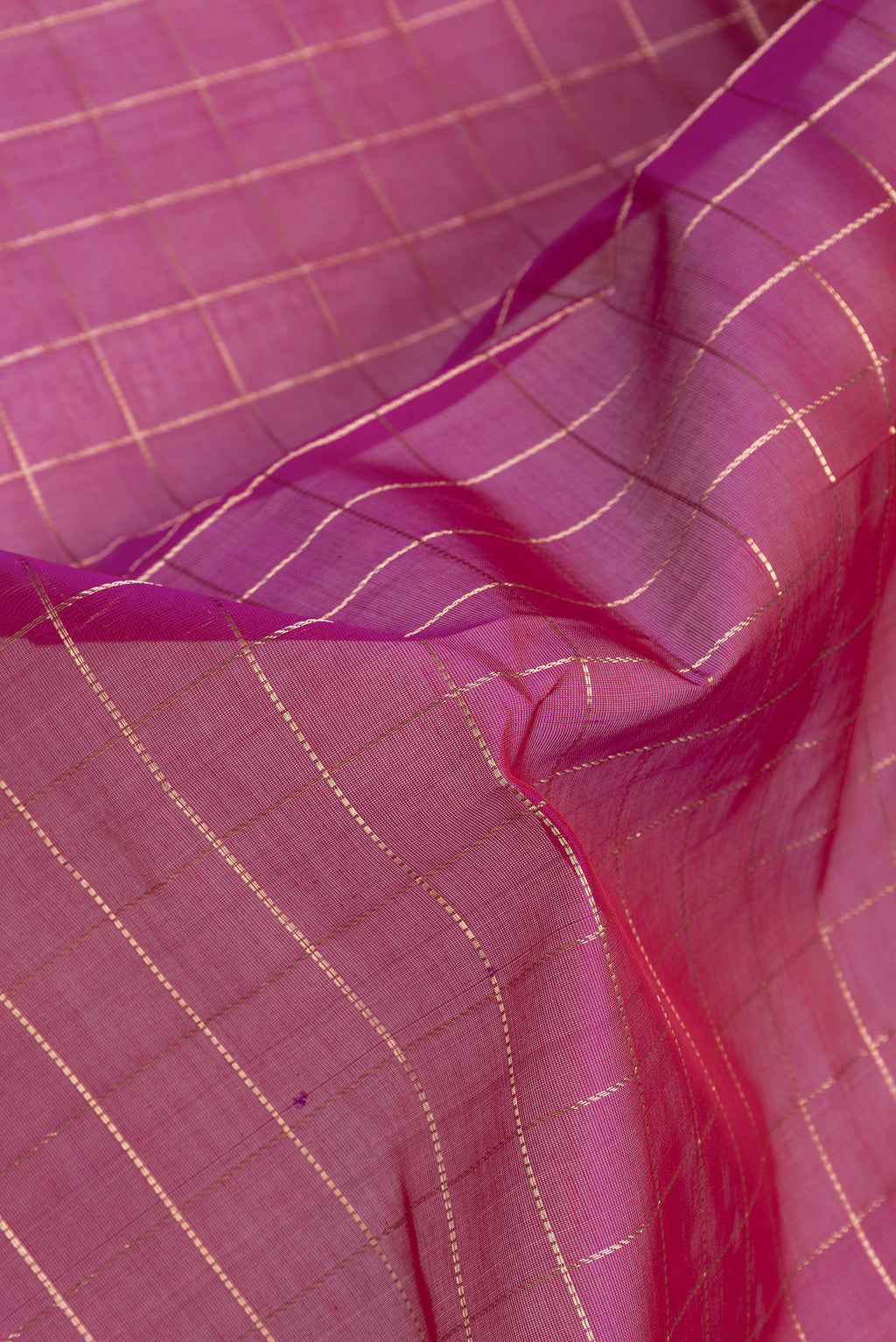 Close up of Magenta Dual Tone Silk Cotton Saree with Checked design on the body and Zari Border.  displaying folds