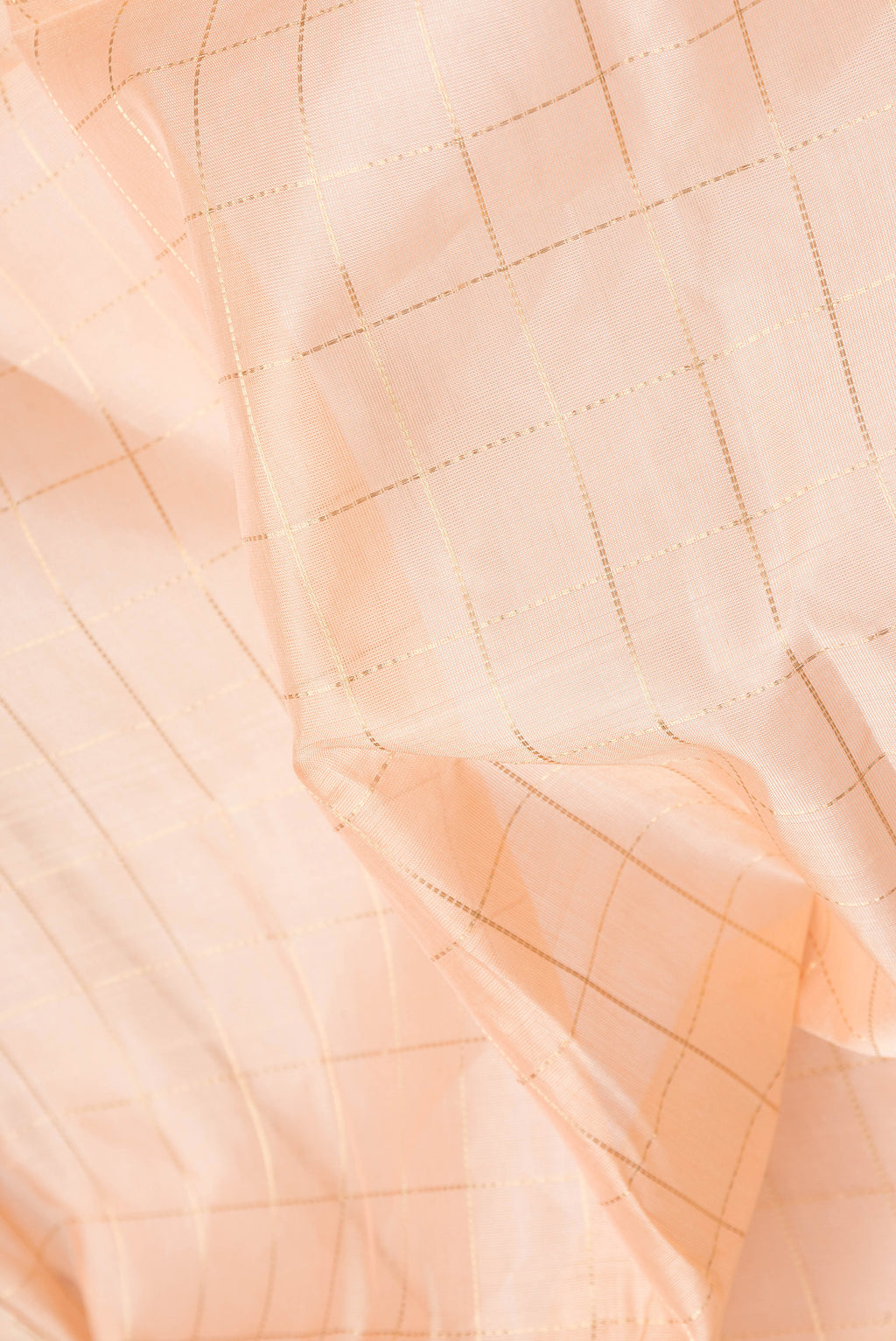 Close up of Golden Peach Dual Tone Silk Cotton Saree with Checked design on the body and Zari Border.  displaying folds