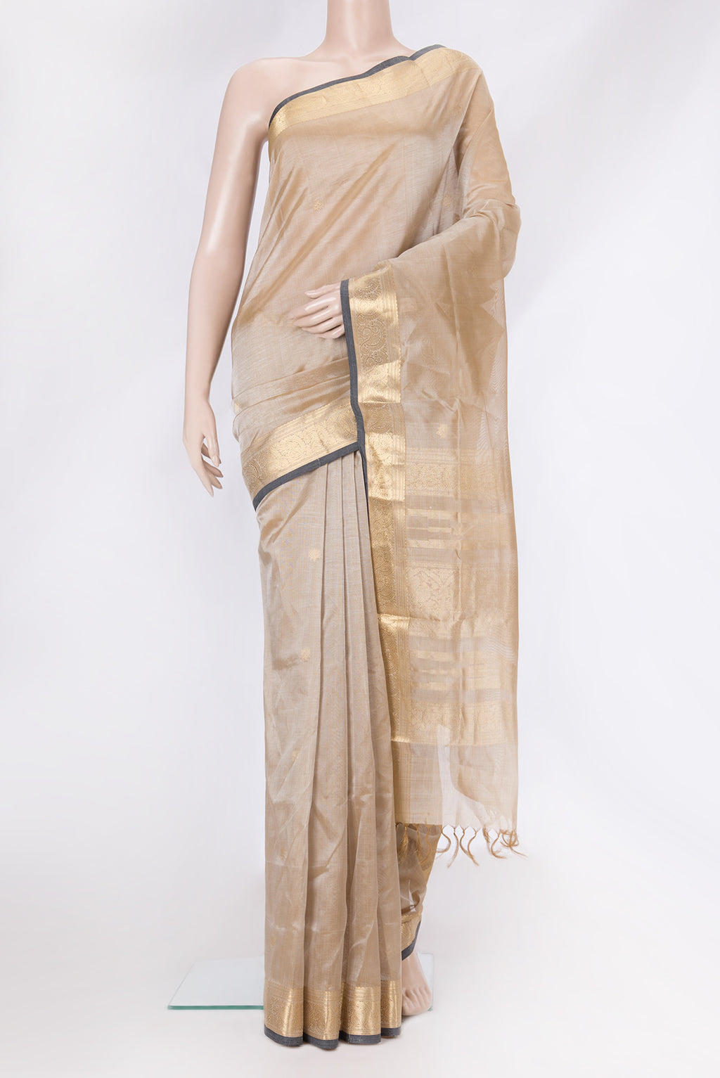Beige Dual Tone Silk Cotton Saree with Zari Butta on the body and Zari Border.  displayed on a mannequin