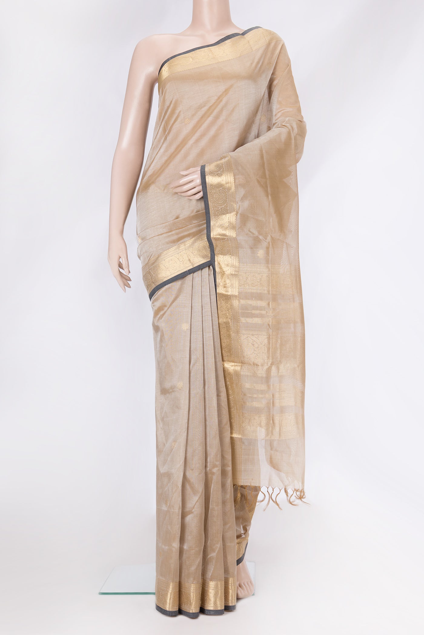 Beige Dual Tone Silk Cotton Saree with Zari Butta on the body and Zari Border.  displayed on a mannequin