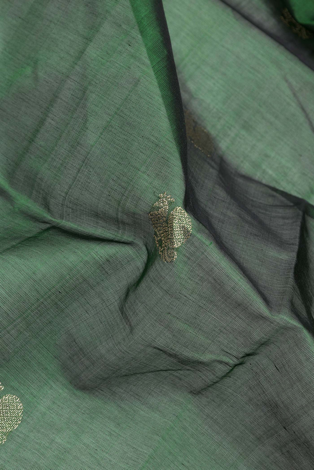 Close up of Bottle Green Dual Tone Silk Cotton Saree with Zari Butta on the body and Zari Border.  displaying folds