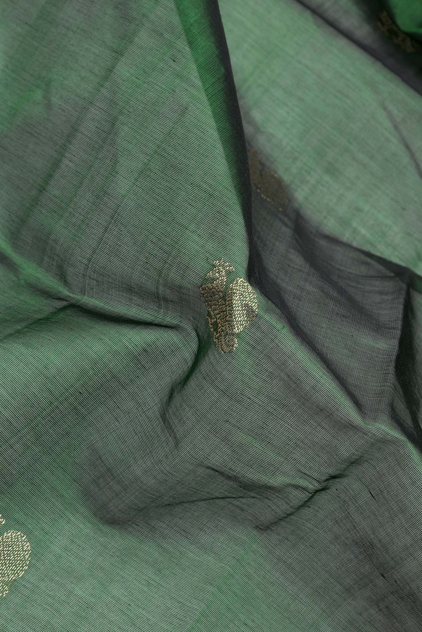 Close up of Bottle Green Dual Tone Silk Cotton Saree with Zari Butta on the body and Zari Border.  displaying folds