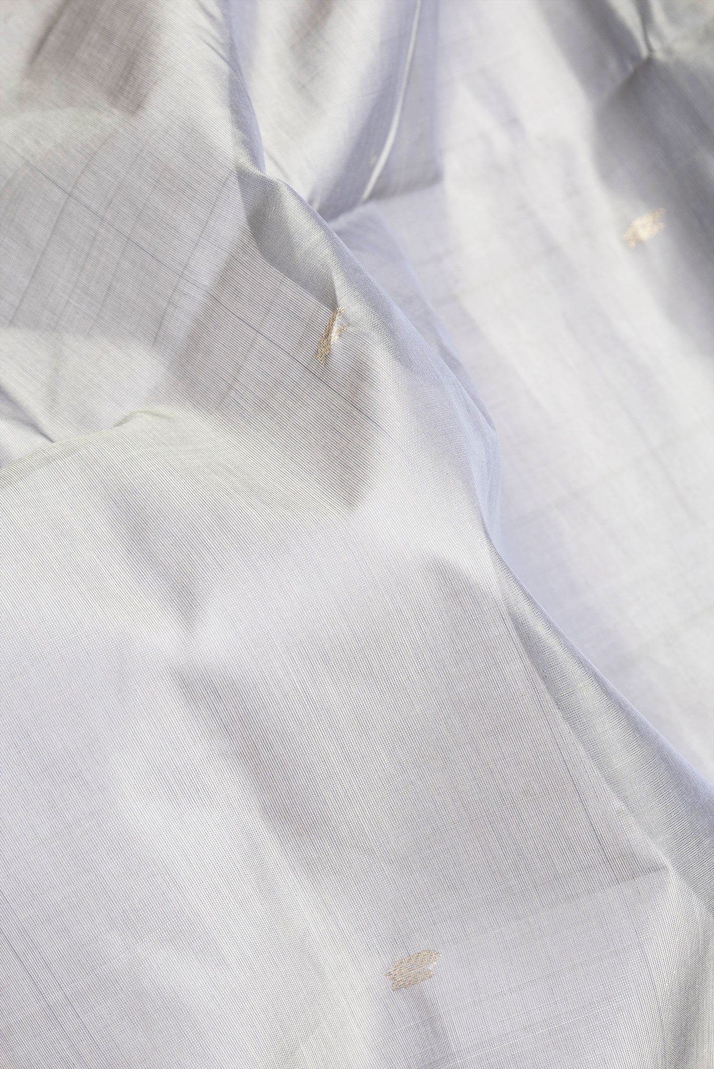 Close up of Grey Dual Tone Silk Cotton Saree with Zari Butta on the body and Zari Border.  displaying folds