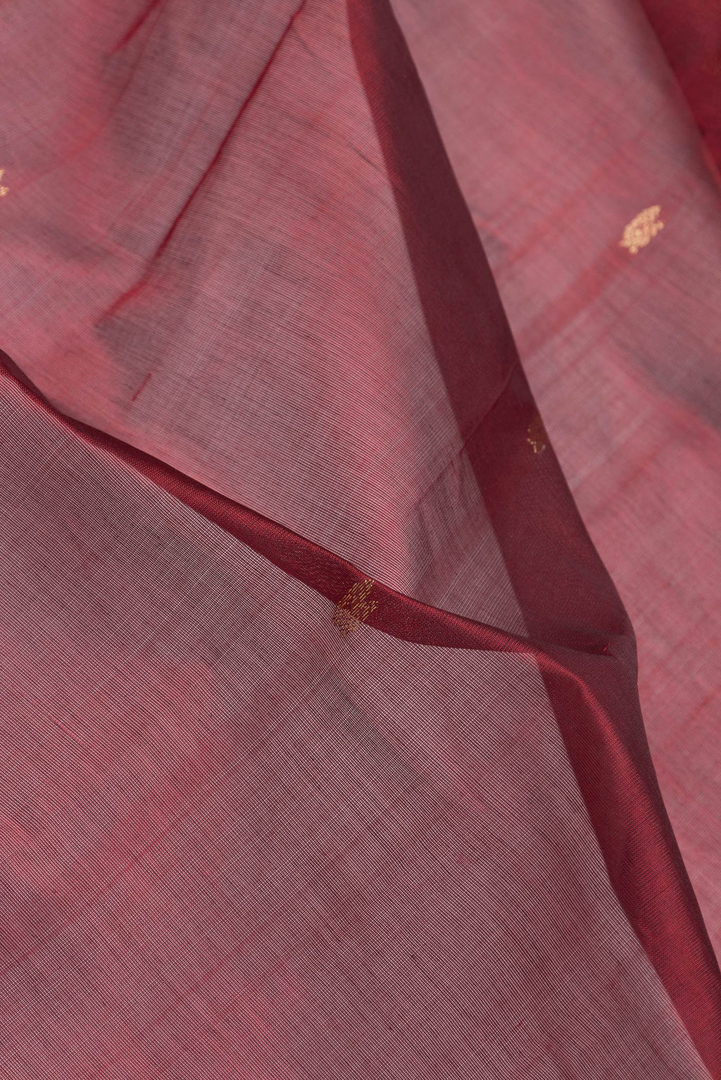 Close up of Maroon Dual Tone Silk Cotton Saree with Zari Butta on the body and Zari Border.  displaying folds