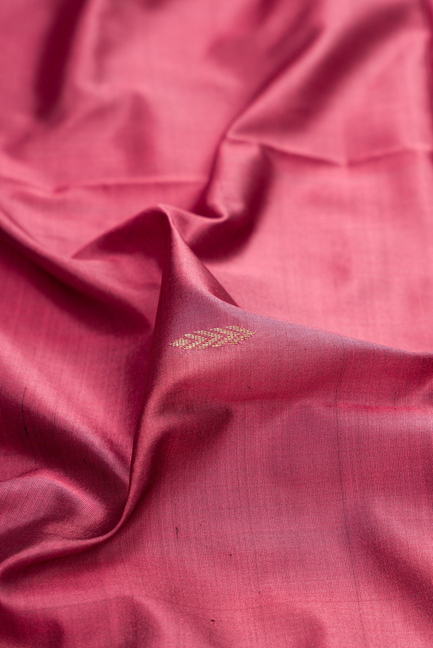 Close up of Pink Maheshwari Silk Saree with Zari And Thread Butta on the body and Zari Border.  displaying folds