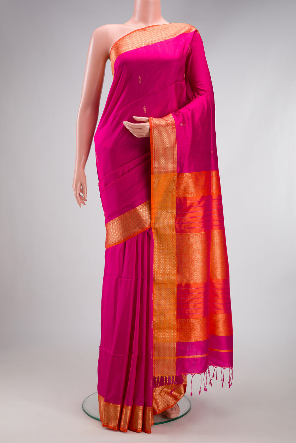 Rani Pink Maheshwari Silk Saree with Zari Butta on the body and Zari Border.  displayed on a mannequin
