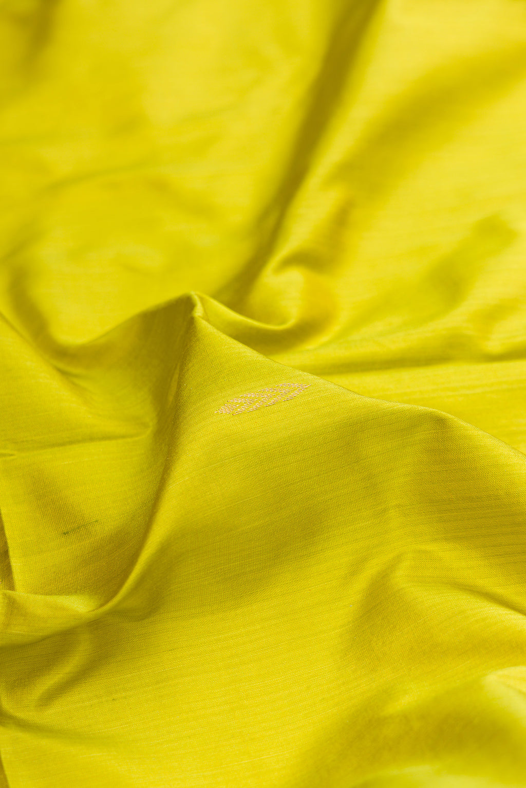 Close up of Parrot Green Maheshwari Silk Saree with Zari Butta on the body and Zari Border.  displaying folds