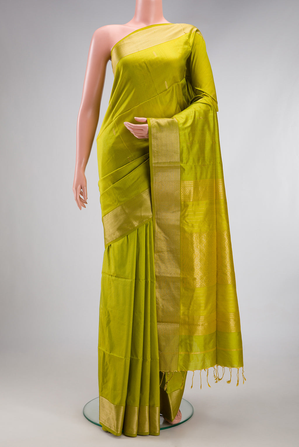 Parrot Green Maheshwari Silk Saree with Zari Butta on the body and Zari Border.  displayed on a mannequin