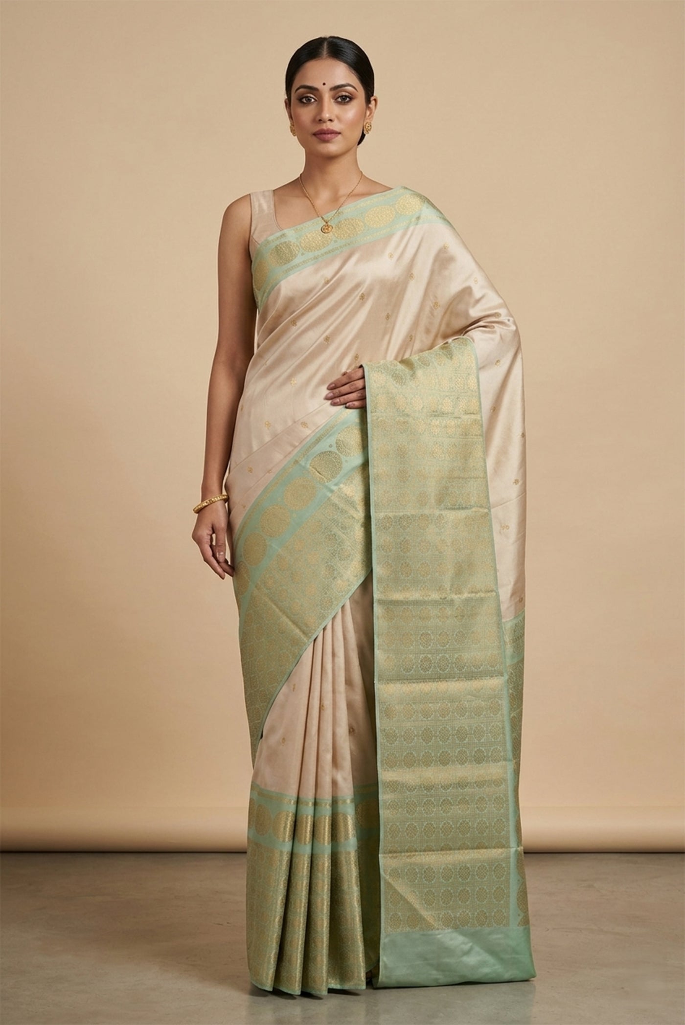 Model wearing a This pure korwai silk saree with gold zari strikes a graceful balance. The cream body is adorned with subtle kamalam butas, while the pastel green asymmetric borders feature kamalam kattam, mayil motifs and a rare maan inspired by the Ramayana. The pallu shines with pavun (coin) motifs and zari lines, finished in a sharp and regal composition.