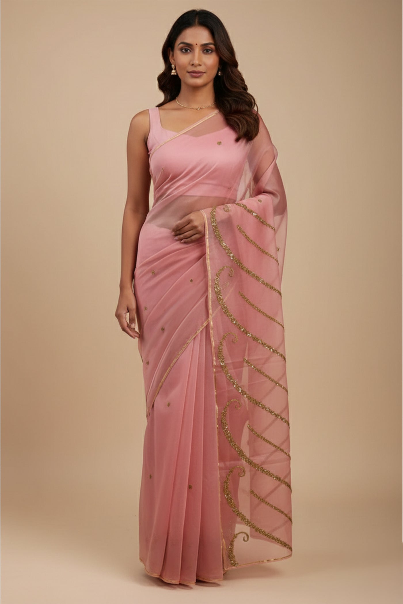 Model wearing a Sitara, crafted in silk organza and embroidered in antique-gold zardozi, draws from Art Nouveau?s love for organic, nature-led forms and the graceful contours of butterfly wings The pallu features striking V-shaped motifs filled with floral embroidery, worked in dabka, sequins, and beads, alternating between dense and lighter forms A minimal floral body allows the statement pallu to unfold with soft grandeur