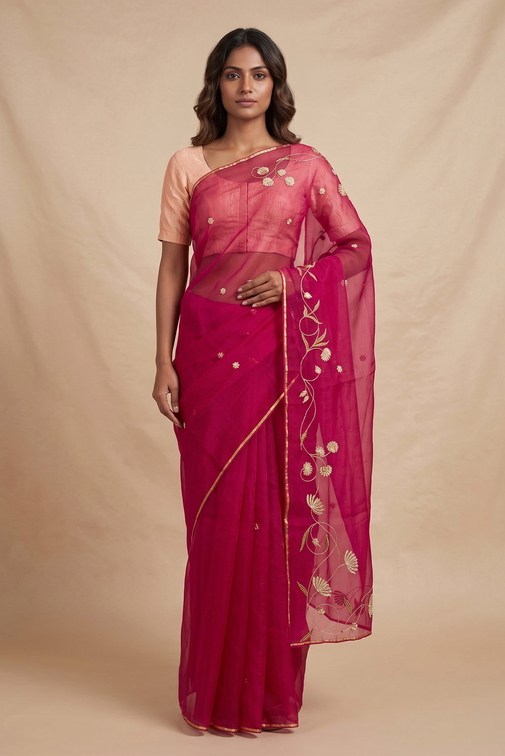 Model wearing a Bahar, crafted in silk organza, features delicate pani-zari enriched with zardozi, gota work, and dabka embroidery. Its defining element is an off-center floral vine running vertically through the body, breaking symmetry with quiet intent. Inspired by Art Nouveau?s flowing lines, the vine is rendered in slender leaves, zari chain-stitched stems, and alternating gota and zardozi flowers. The pallu trails gently onto the body in scattered embroidered blooms.